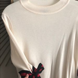 Cream sweater with black and red bow